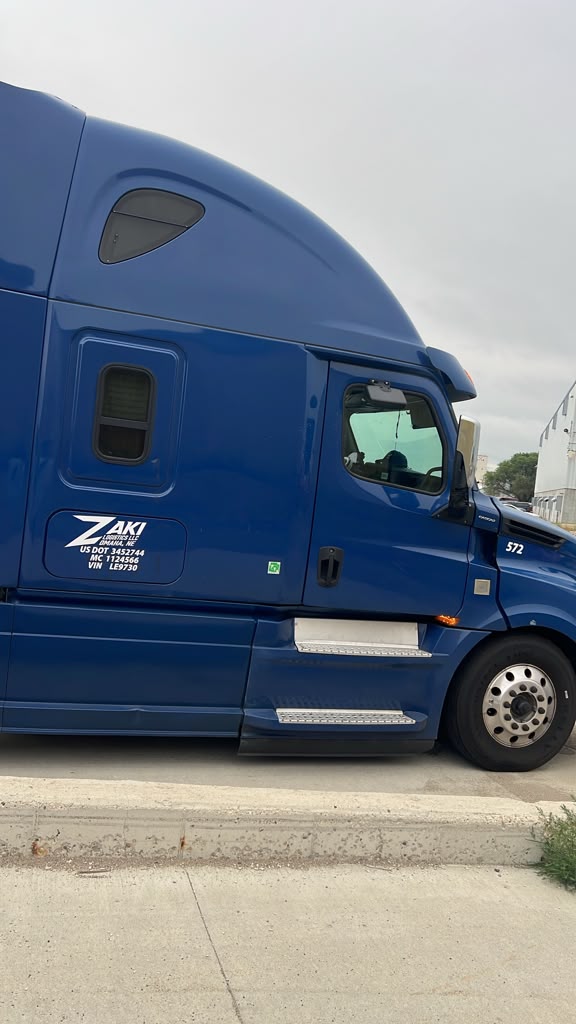 ZAKI Logistics blue Freightliner tractor, unit 572, with the company door decal